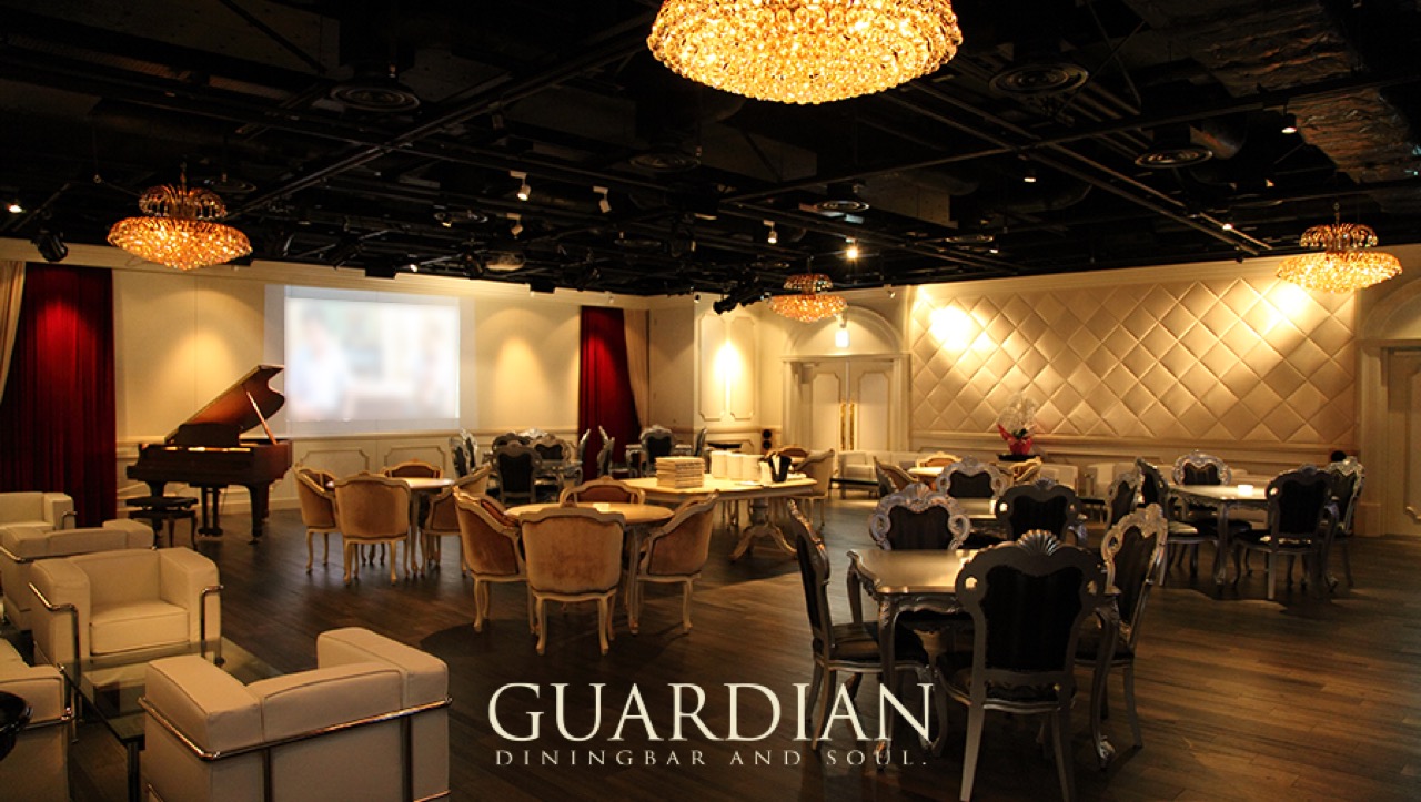 GUARDIAN DINING BARの店内・シャンデリアとグランドピアノのある宴会ラウンジ席