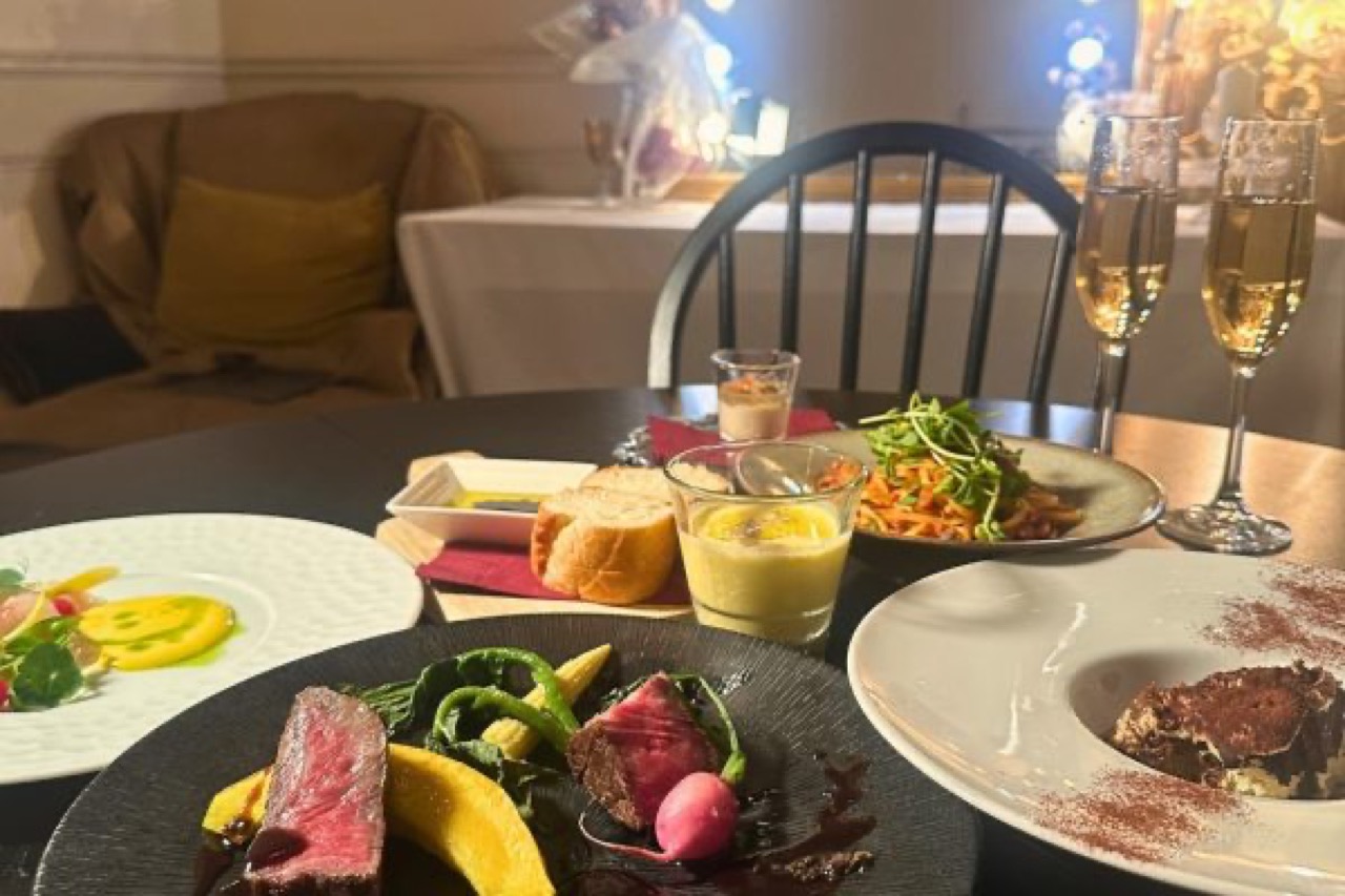 IDOL 表参道の店内・テーブルに並ぶコース料理とシャンパングラス