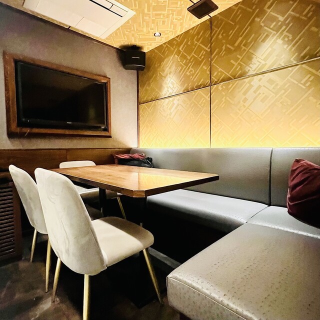 itO The Thread 恵比寿店 ゴールドパネル壁のテーブル席とグレーソファ