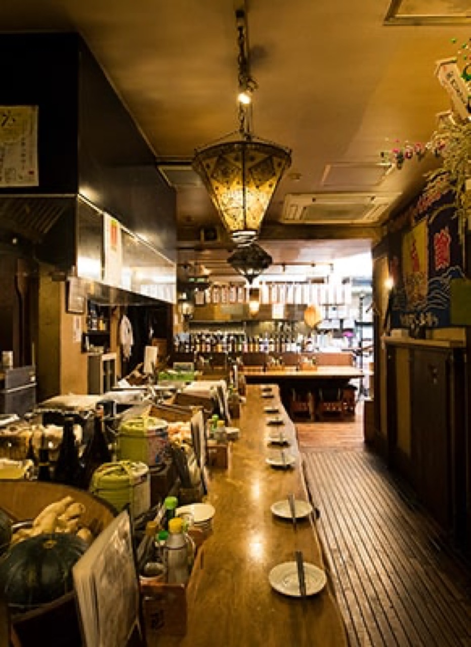なかめのてっぺん 本店の店内・木目の長いカウンター席と和の照明