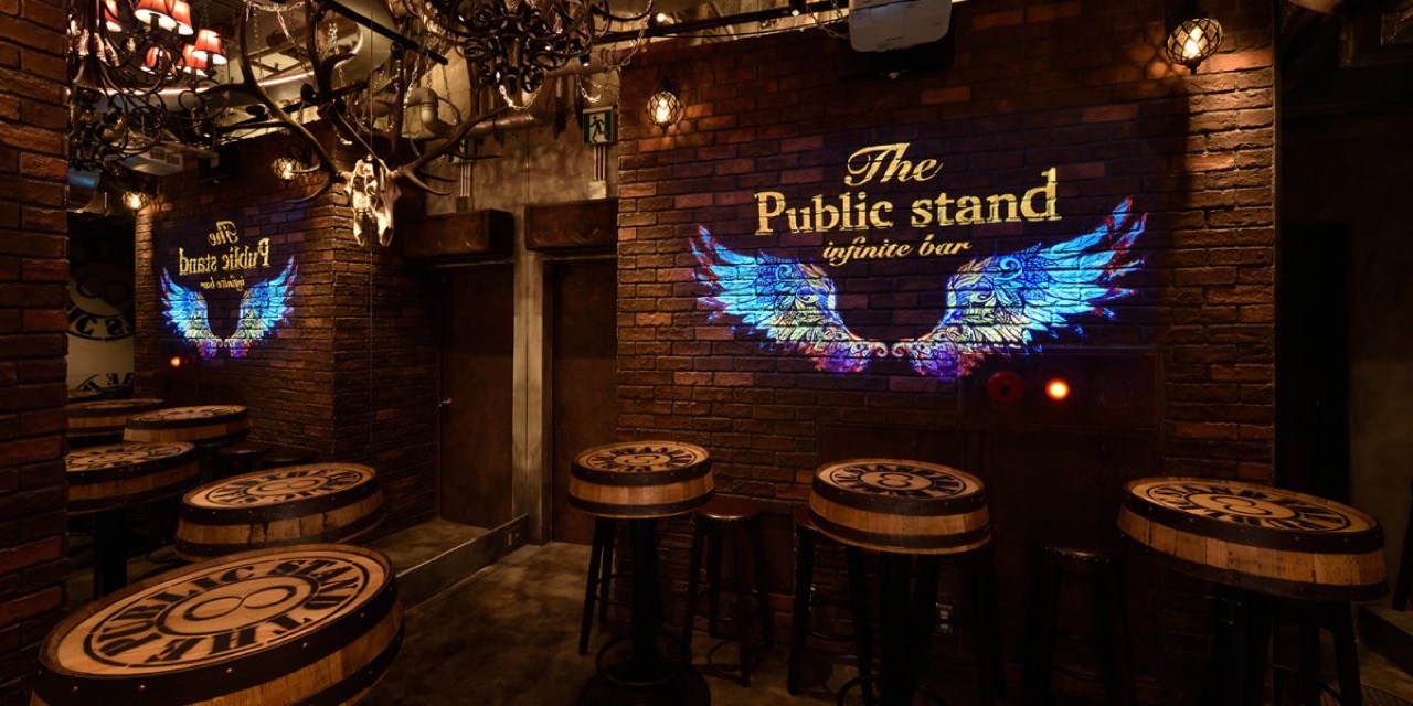 The Public stand 新宿歌舞伎町店の店内・レンガ壁とロゴ演出のバー席