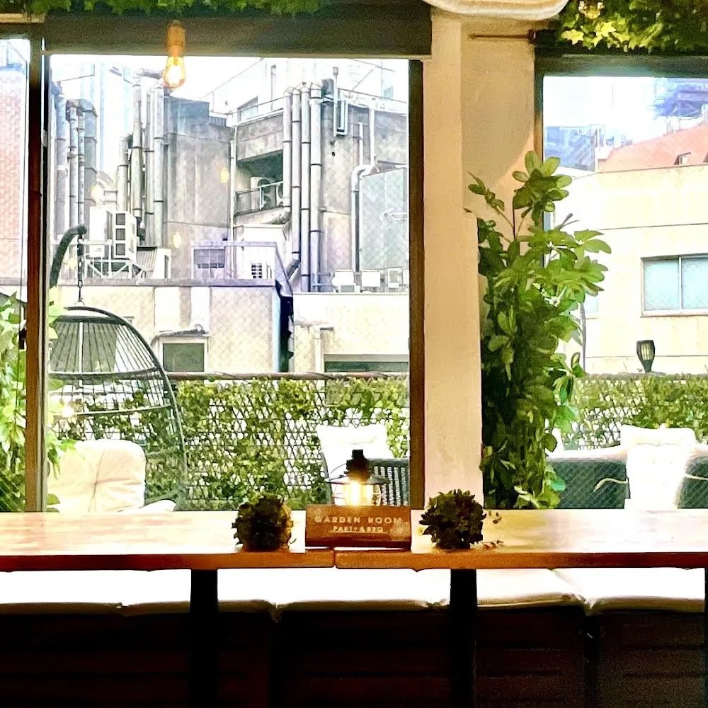渋谷ガーデンルーム（4F）テラスのハンギングチェアと「GARDEN ROOM」サイン