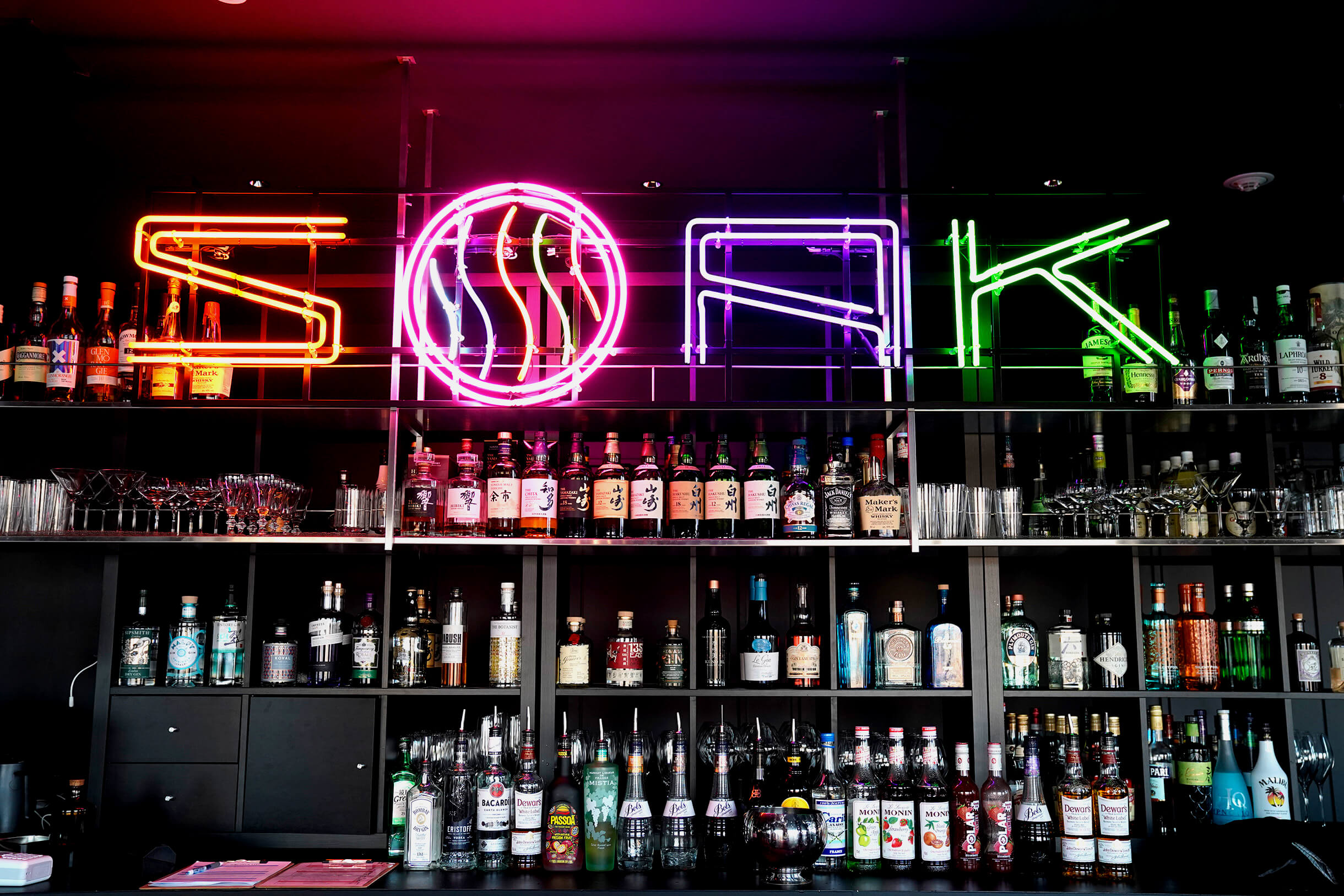 SOAK 渋谷「SOAK」ネオンサインとバックバーのボトル棚
