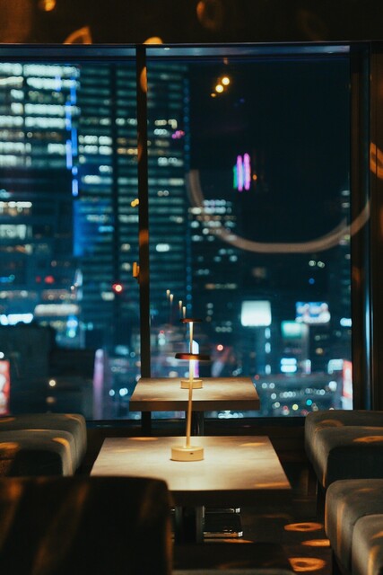 SOAK 渋谷 窓辺のテーブル席とテーブルランプの夜間演出